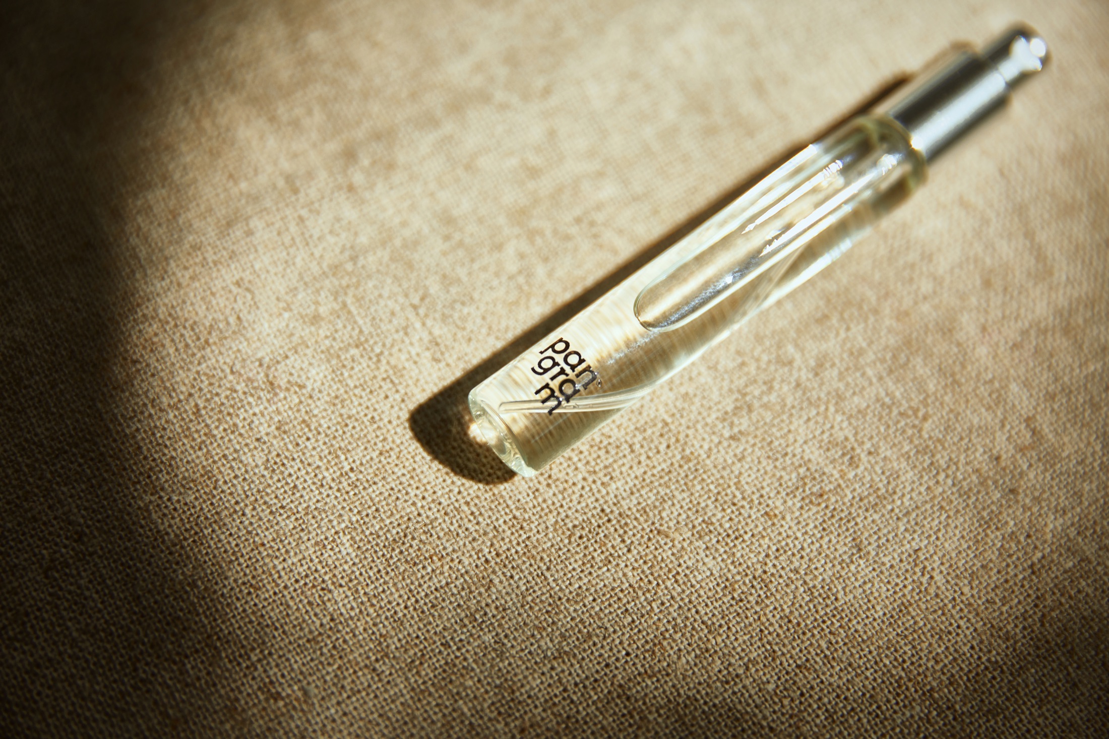 Pangram glass vial on linen texture