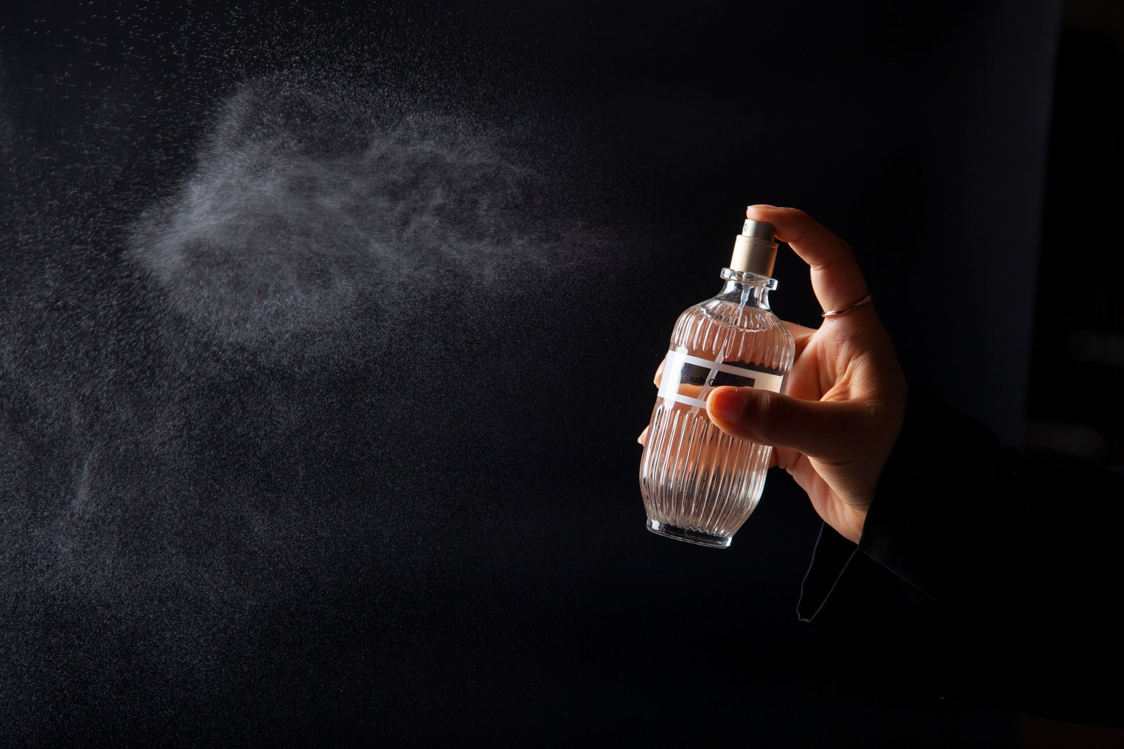 Consistent spray testing — mist being dispensed from an actual perfume bottle